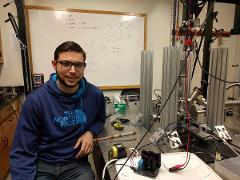 student next to lab equipment