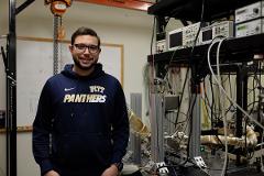 student in front of lab equipment including lots of wires