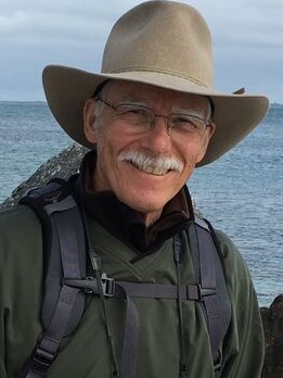 Bob Gresswell in a hat in front of a body of water