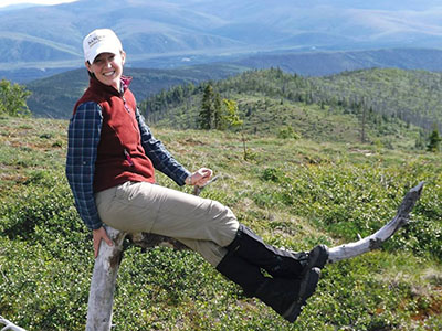 smiling woman outdoors above treeline