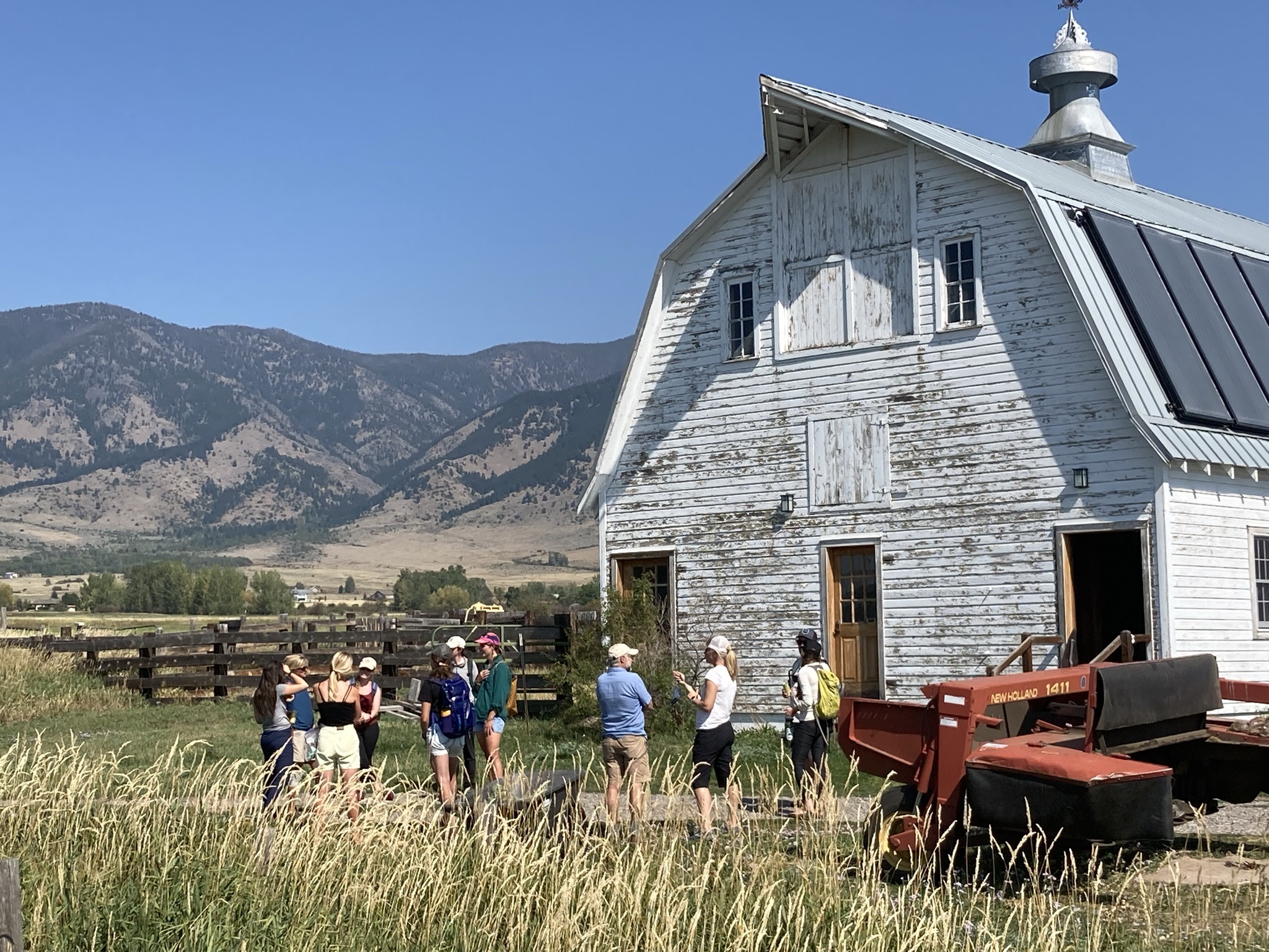 White barn with students and professors out front