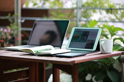 two laptops and a coffee mug on a table