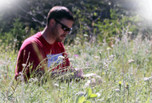 Student Reading in Field Photo: Student Reading in Field