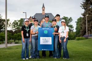 group holding blue county sign. 