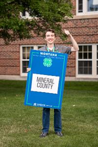 group holding blue county sign. 