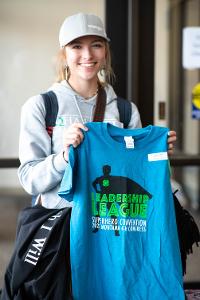 girl holding up blue congress tshirt