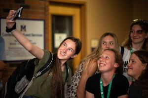 girl holding arm out taking a selphie of the group