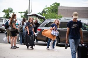 kids unloading the car and walking into the dorm