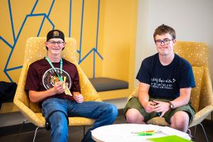 two boys sitting in chairs smiling