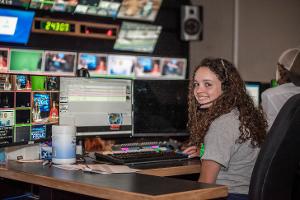 girl sitting in front of screens