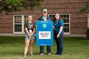 group holding blue county sign. 