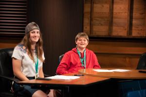 two kids sitting at anchor desk