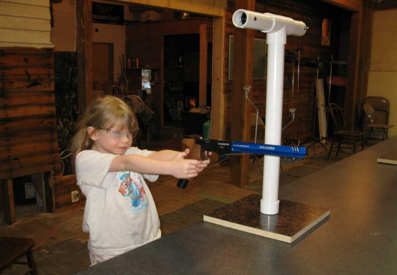A girl aims a pistol