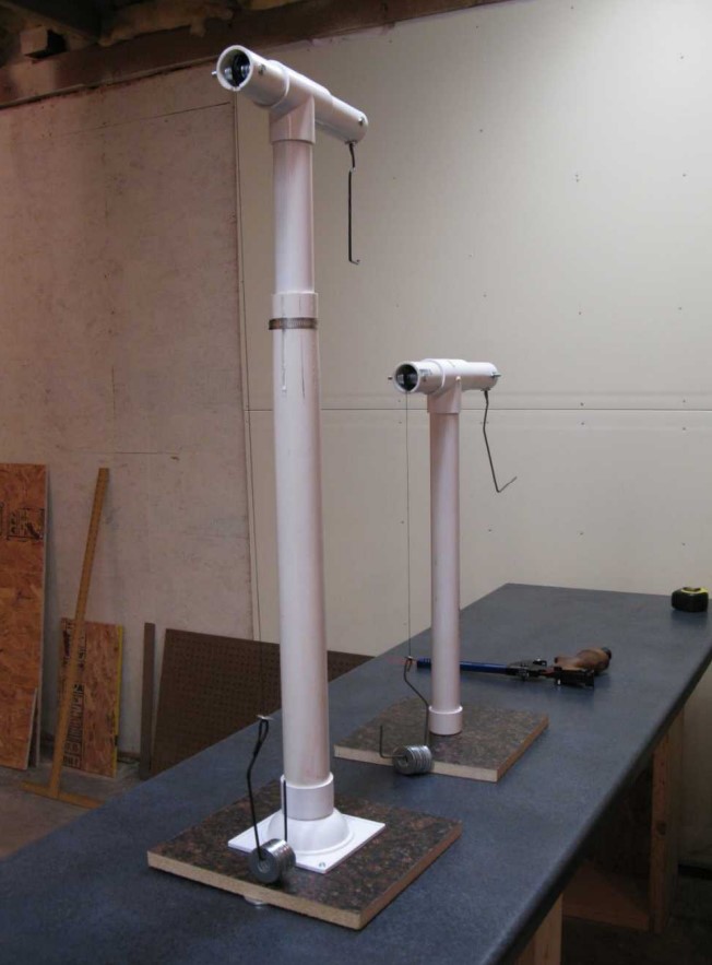 Two completed T-stands of different sizes stand on a table