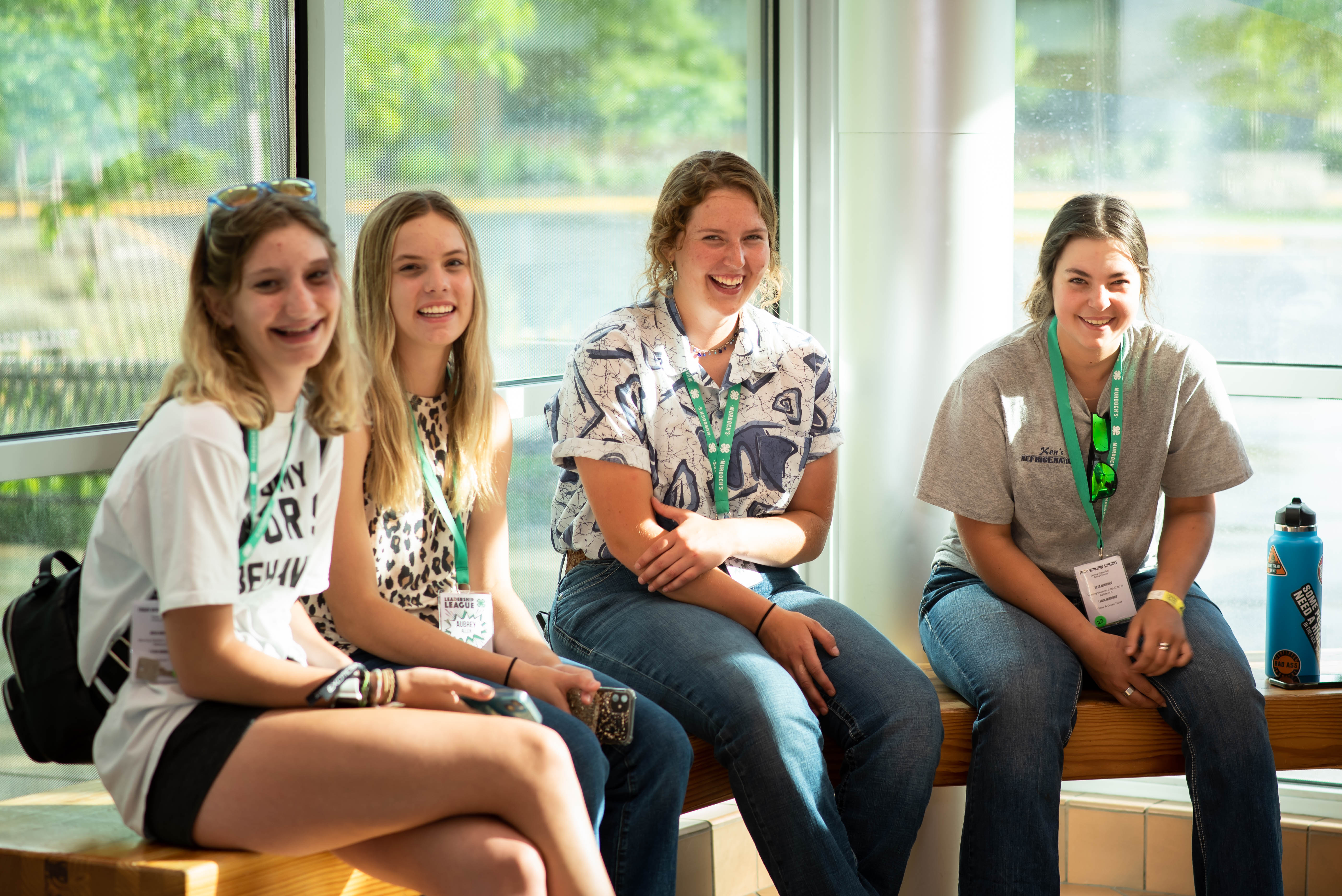 girls sitting in a group in front of window