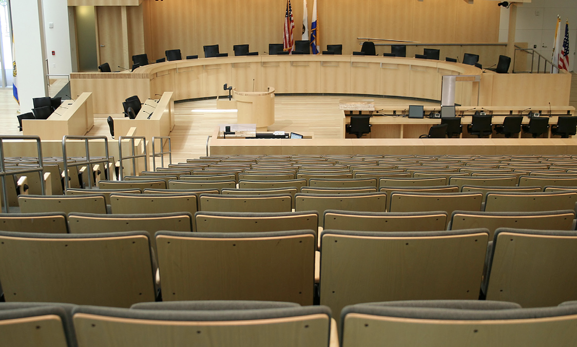 a large room with audience seating and a panel set up.