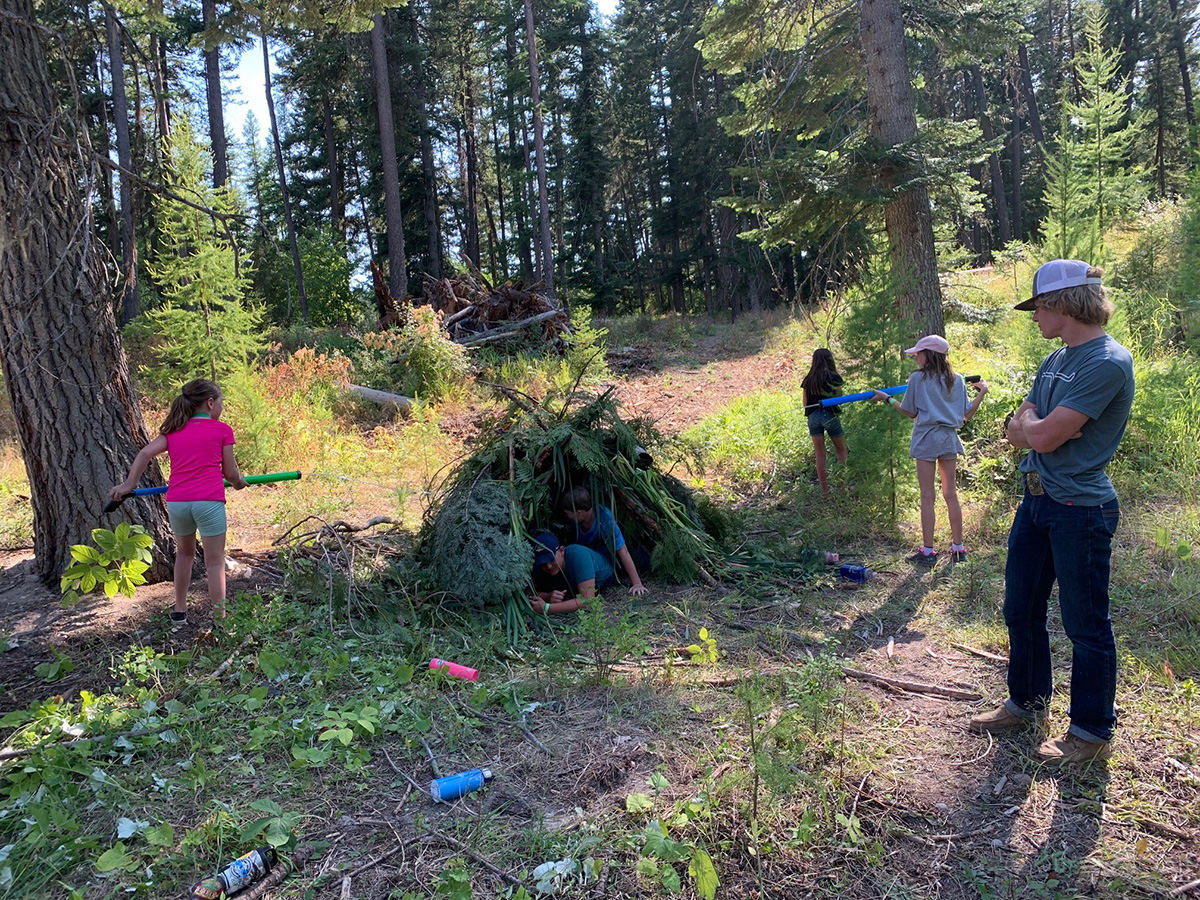 Flathead County 4-H Campers test the strength of their primitive shelter with water guns.