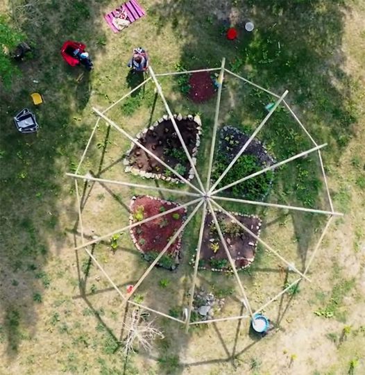 A drone image looking down onto a structure of poles over Newah's Garden 