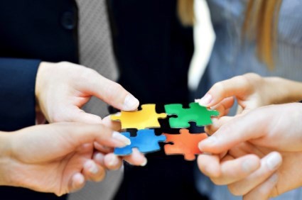 Hands holding puzzle pieces Hands holding different color puzzle pieces