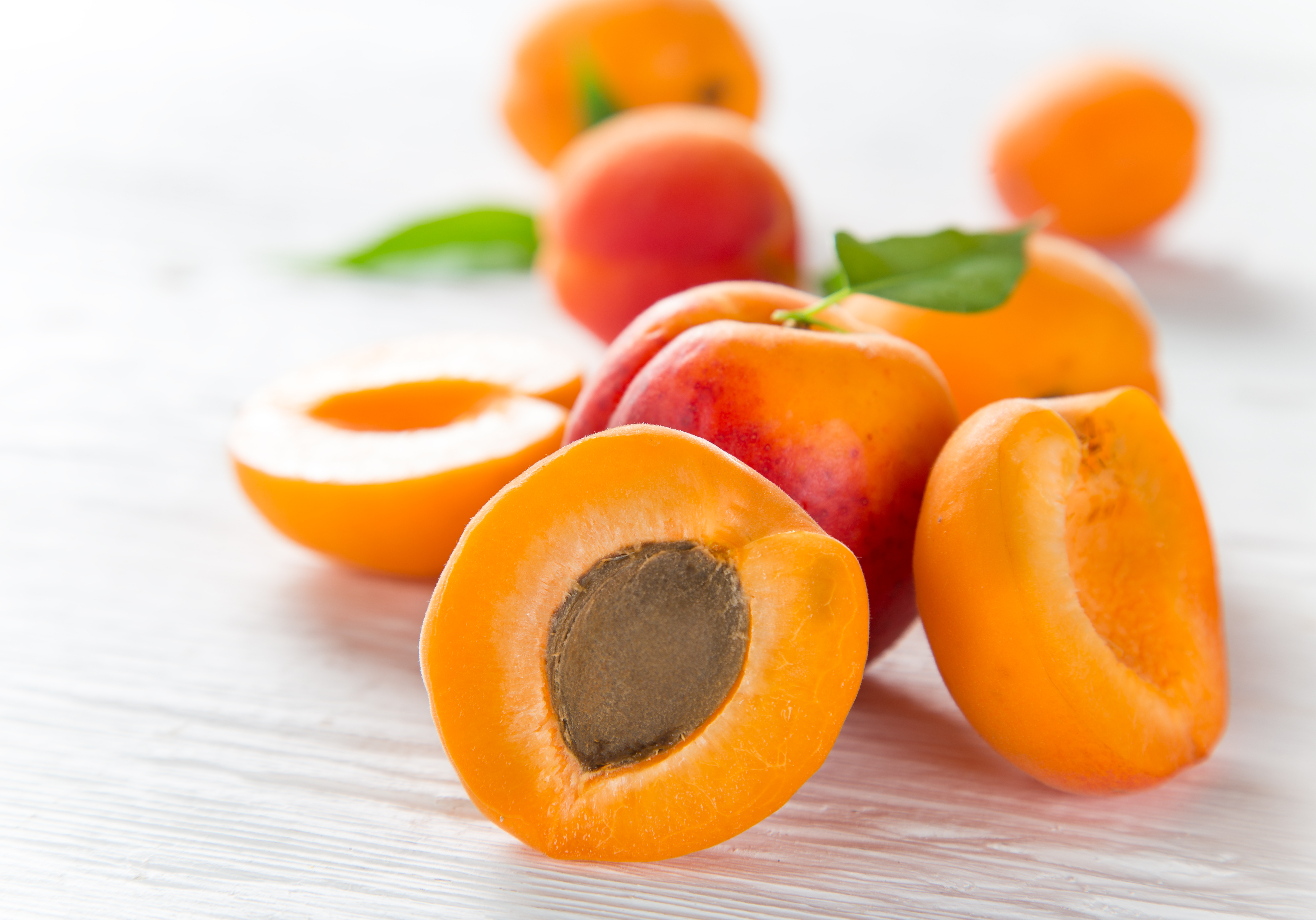 Scliced and whole apricots on counter