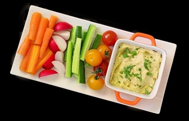 A tray with hummus, tomatoes, cucumbers, radishes, and carrots.