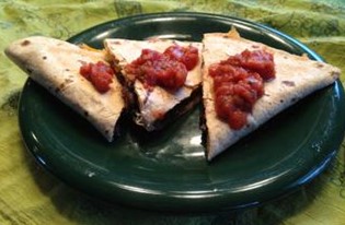 Three slices of Black Bean Quesadilla on a plate topped with salsa.