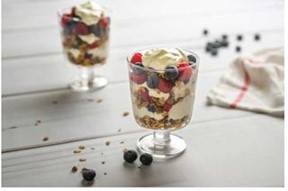 Two Breakfast Parfaits containing granola, yogurt, blueberries, and strawberries.