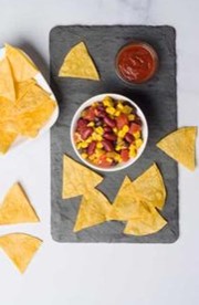 A tray holding a dish of Cowboy Caviaar, tortilla chips, and salsa.