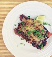 Two enchiladas on a plate topped with cilantro.