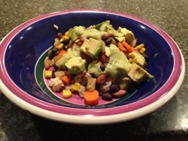 A rice and bean bowl topped with avocado.