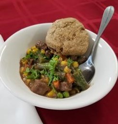 A bowl of Elk Pot Pie with an herb biscuit.