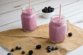 Two jars of Fruit Smoothies topped with blackberries and blueberries.
