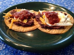 Two tortillas topped with Huevos Rancheros toppings on a plate.