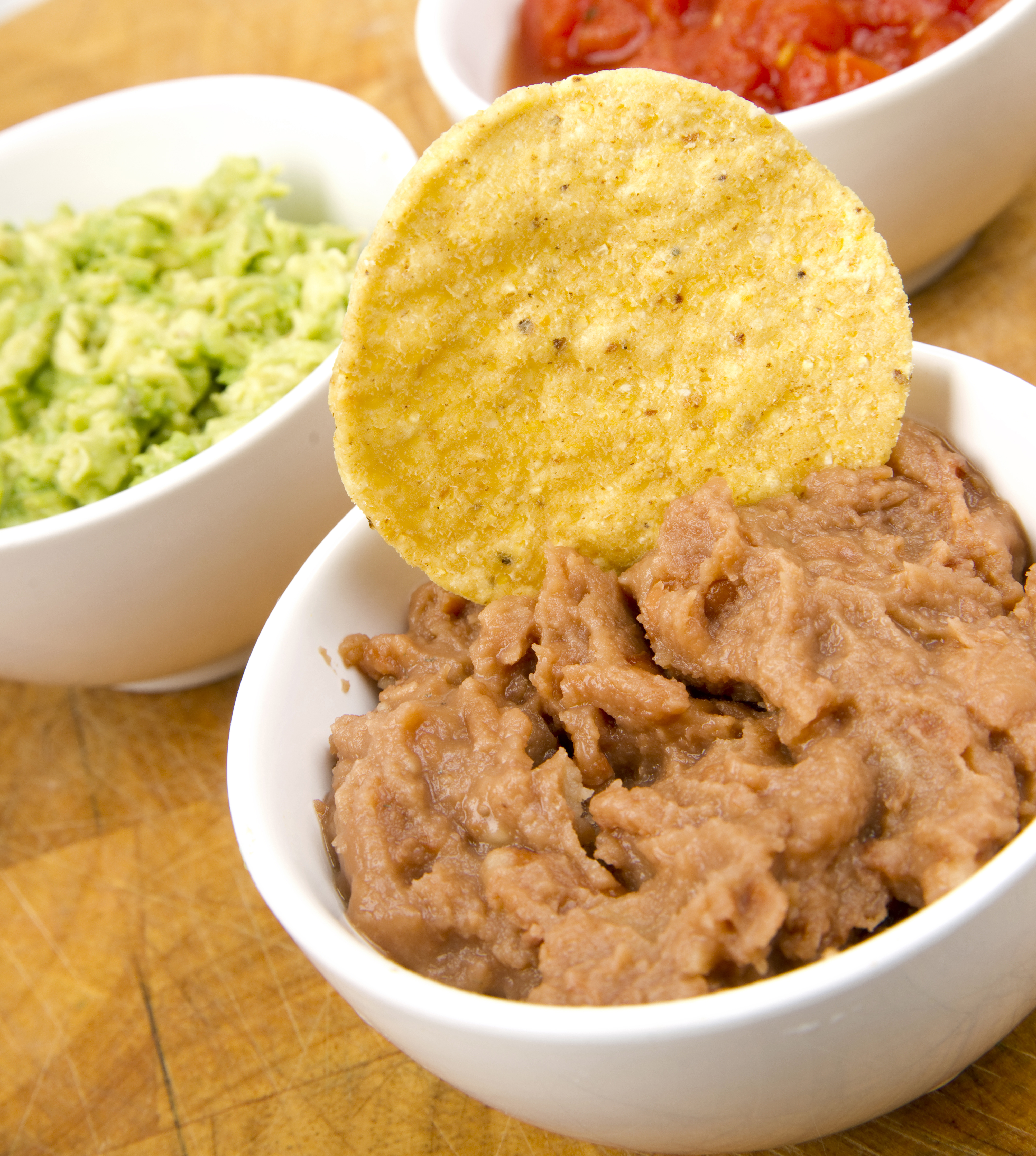 A bowl of 3 bean salad with chips.