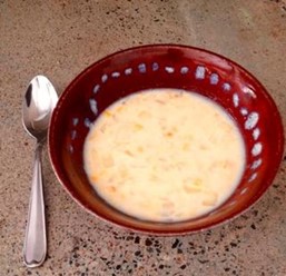 A red bowl containing skillet corn chowder.