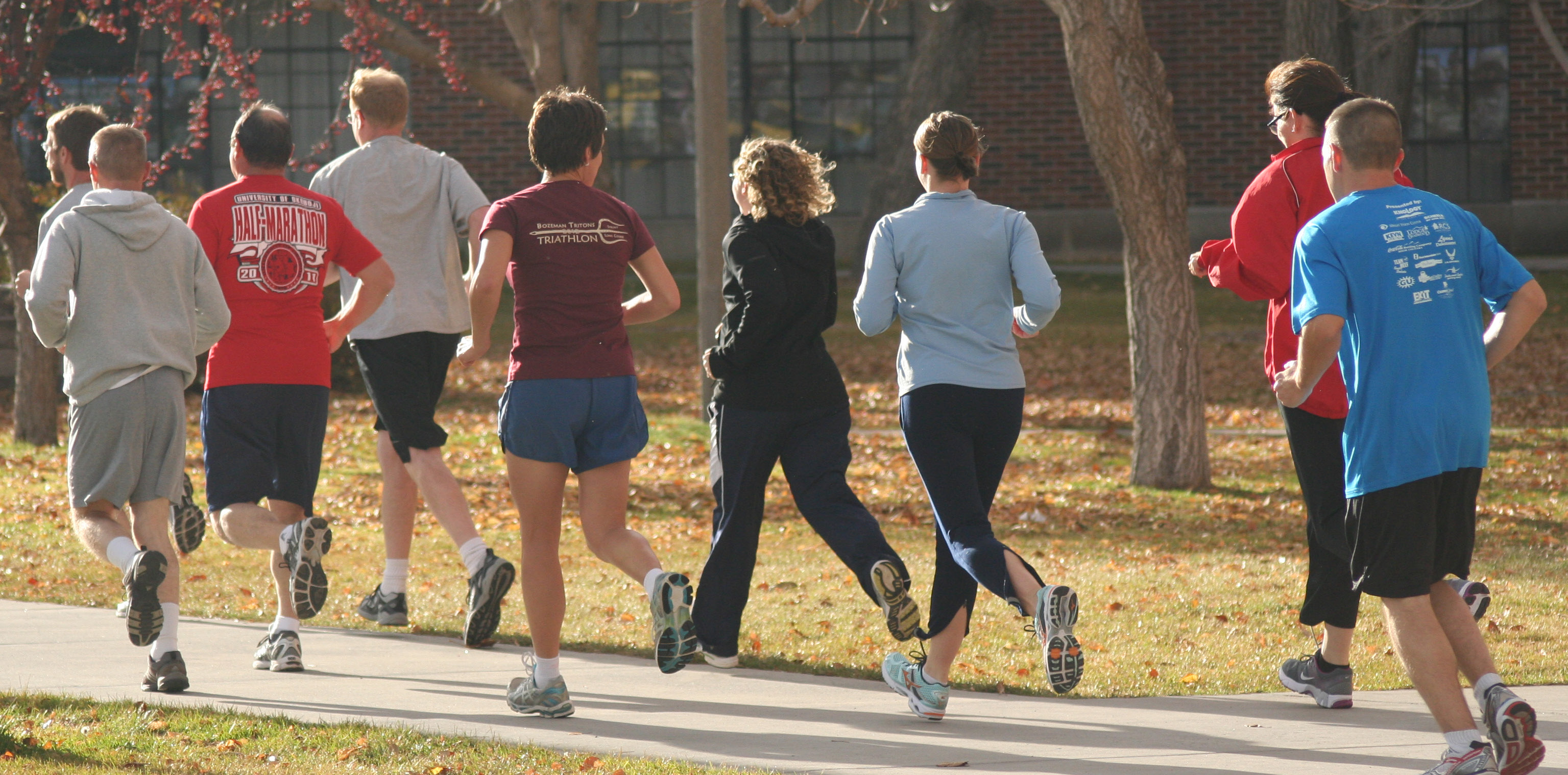 A group of men and women in exercise clothes on a run together.
