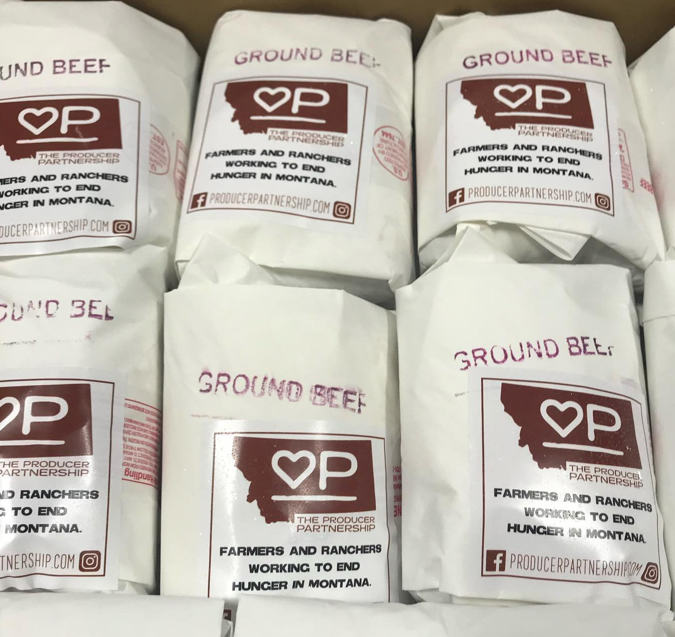 packages of ground beef wrapped in white paper, with Producer Partnership labels on them.