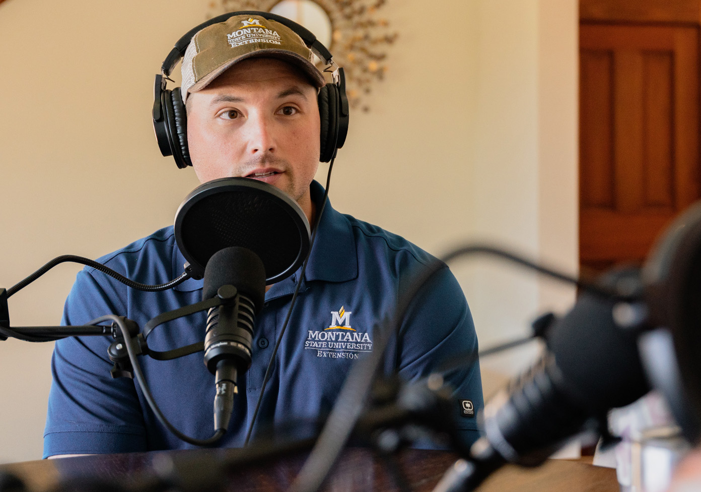 Jared Beaver, PhD, presenter of Working Wild U Podcast, sits behind a podcast microphone.