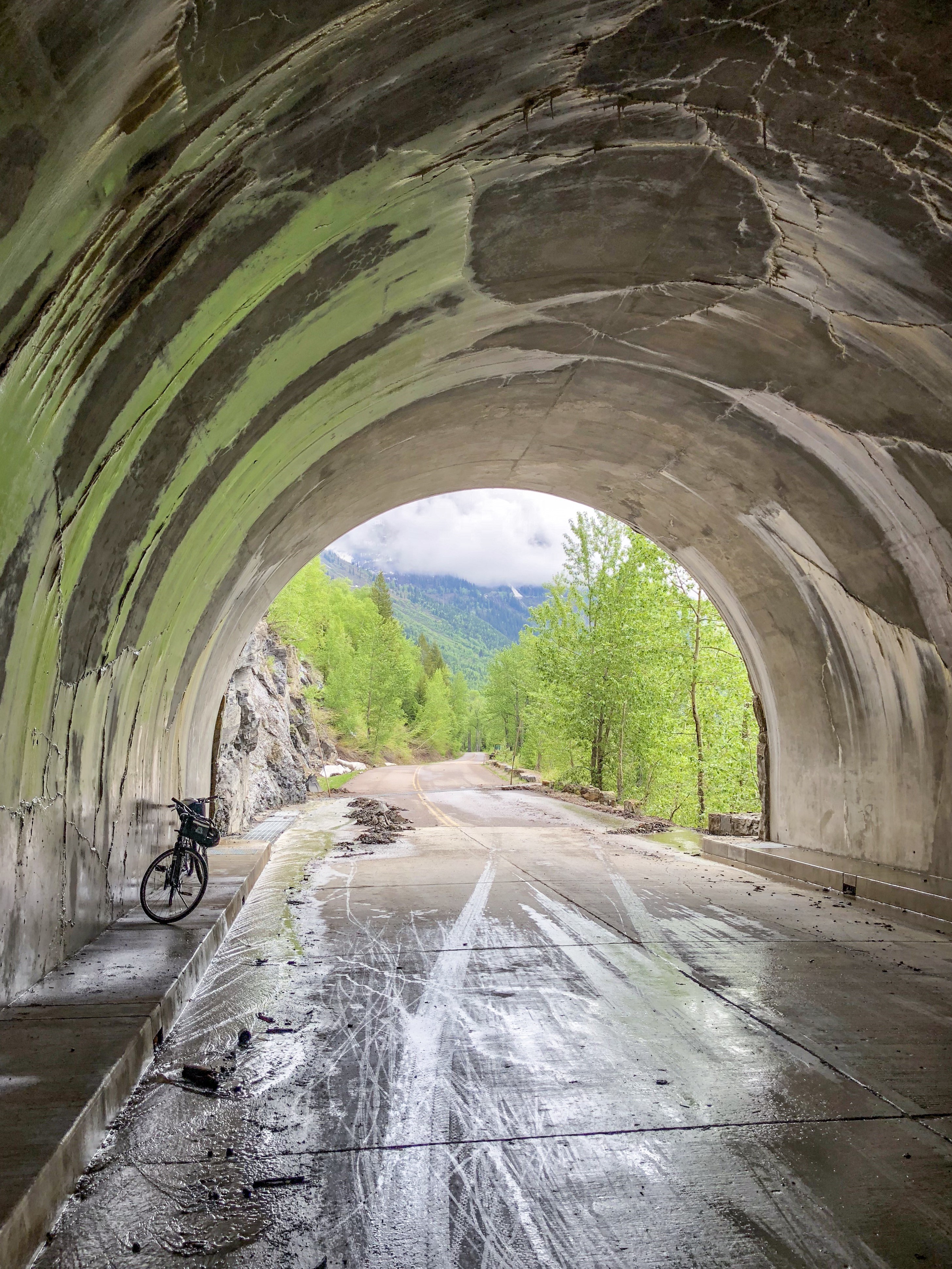 View of Going to the Sun Road in Glacier National Park from a tunnel with a bicycle