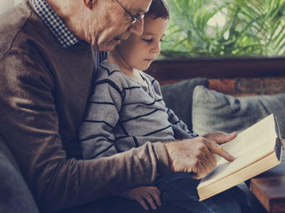 grandpa reading book to grandson