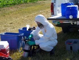 Photo of a person in full PPE, including fit tested respirator.