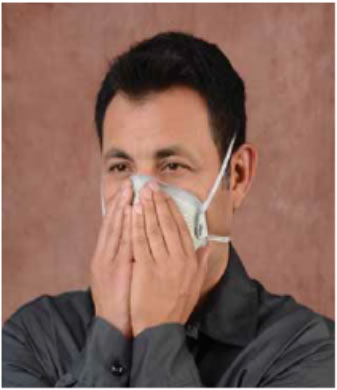 photo, man cupping his hands over the respirator to test for leaks