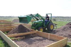 Lyman Amsden dumping dirt with tractor