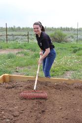 Teen raking dirt