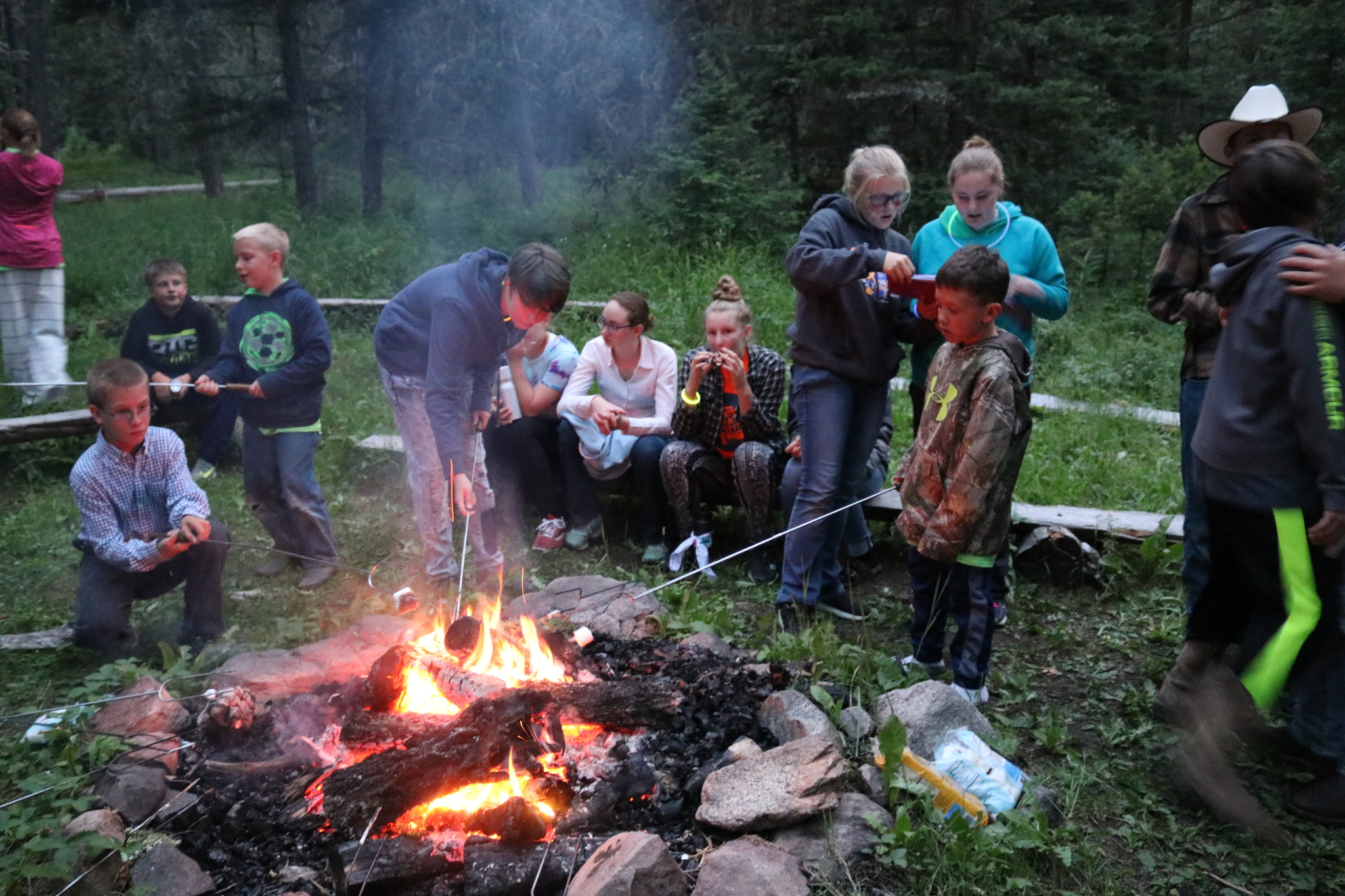 Teton County 4-H campers around the campfire roasting marshmellows.