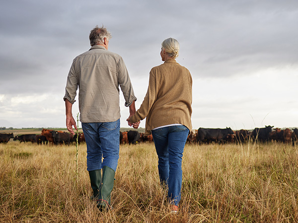 Mature farming couple holding hands 