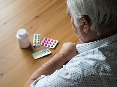 Man looking at pills on a table