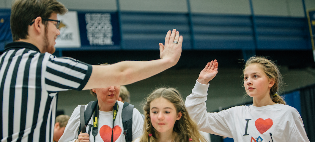 volunteer and two girls high-fiving