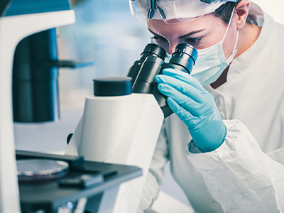 woman looking through microscope