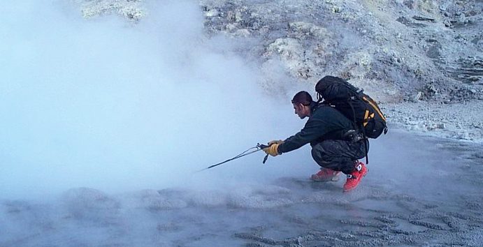 Male student uses temperature probe in thermal hot spring